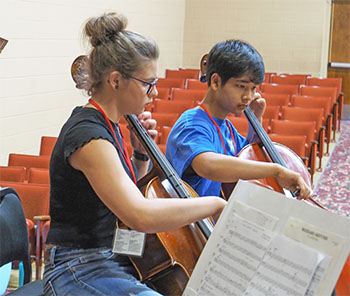 two students playing cello