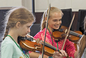 Two girls playing violin