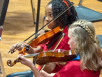 two girls playing violin