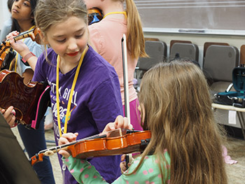 Two girls playing violin