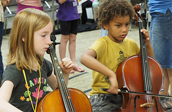 two children playing cello