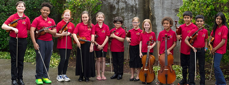 Children with instruments in red shirts