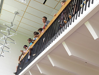 students along balcony singing