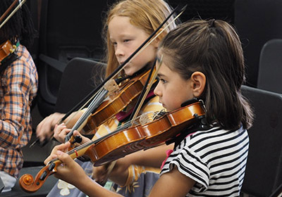 two small girls playin violins