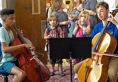 boys playing cello - children watching