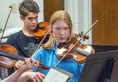 two students playinj violins