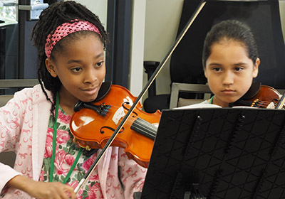 two girls playing violin