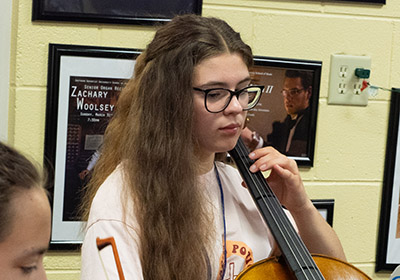 girl with long hair playing cello