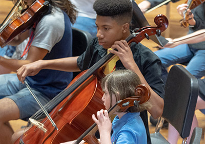 young man and small girl playing cello
