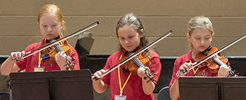 three girls playing violin