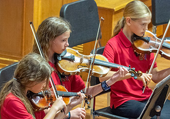 three girls playing violin