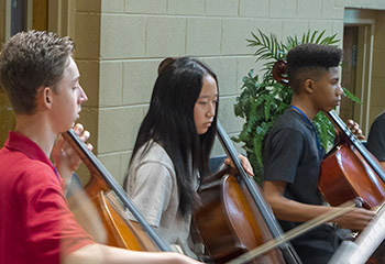 Young people playing cellos