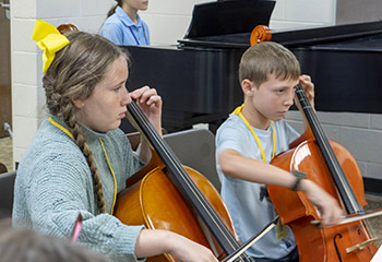 two children playing cellos