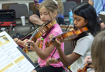 two girls playing violins