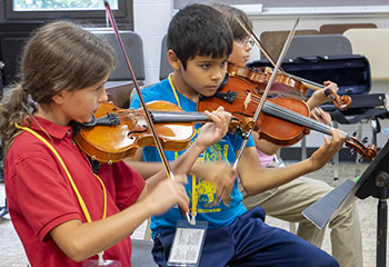 Two children playing violins