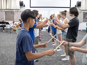 young people using rhythm sticks