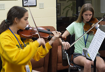 two girls playing violins