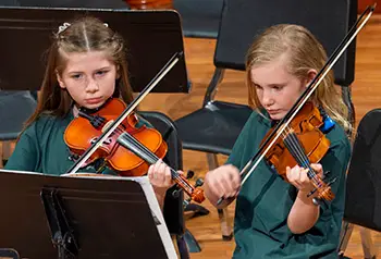 2 girls playing violins